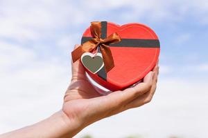 Hand holding a heart shaped box photo