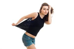 pretty interesting young brunette posing in the Studio in a t-shirt and shorts photo