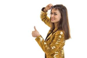 Young stylish brunette in golden jacket posing on camera photo