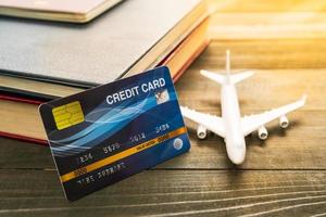 Credit card and airplane model on wooden table photo