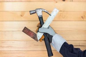 Hand in glove holding iron ruler and hammer photo