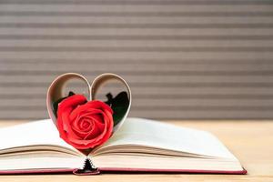 páginas de libro en forma de corazón curvo con rosa roja foto