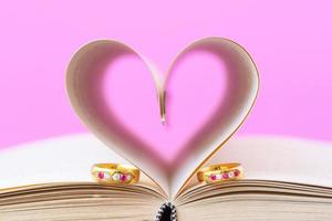 Pages of book curved  heart shape and weeding ring photo