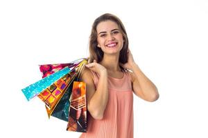 una chica buena y hermosa sostiene en su mano muchos paquetes coloridos con compras aisladas de fondo blanco foto