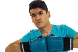 serious sports man posing in blue boxing gloves in studio isolated on white background photo