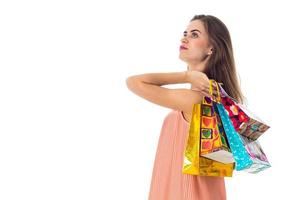 the girl stands sideways on the shoulder and raised beautiful bags isolated  white background photo