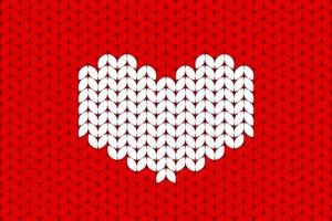 White knitted heart on red background. Valentines day background in a wool knitted pattern photo