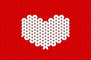 White knitted heart on red background. Valentines day background in a wool knitted pattern photo