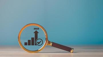 A magnifying glass is placed on the table,business growth and success graph concept of progress in development Financial efficiency and investment with business strategies for goals. photo