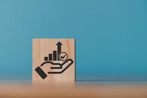 Wooden block and businessman hand icon showing business growth and success graph.concept of progress in development, financial efficiency and investment with business strategy for goals photo