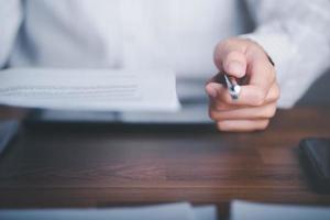 businessman handing documents and pen to client,Management of business documents and agreements, signing of business contracts, approval of contract documents or warranty certificates photo