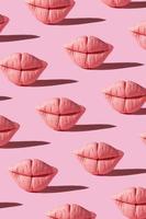 Pattern from pink lips on pink background. Creative beauty concept vertical background photo