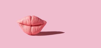 Polymer clay pink lips isolated on pink background photo