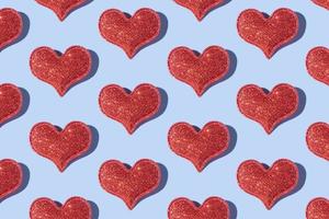 Pattern made from glitter heart shape on colored background with hard shadow. Valentines day minimalistic design photo