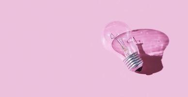 Lamp with hard shadow on pink background. Symbol of creative idea. Light concept photo
