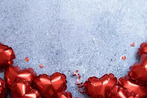 globos con forma de corazón rojo sobre fondo de hormigón. plantilla de tarjeta de felicitación del día de san valentín. copie el espacio foto