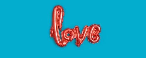 Red baloons Love shape on turquoise background. Minimalistic Valentines Day concept photo