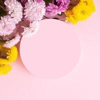 Podium or pedestal and colored flowers on pink background. Summer or spring products temlate or copy space for text photo