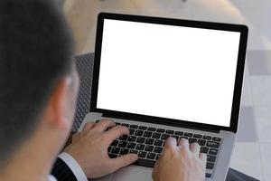 enfoque selectivo del botón táctil de la mano del hombre de negocios en el teclado del portátil. hombre usando computadora portátil con pantalla en blanco. hombre que trabaja en la computadora portátil con las manos. concepto de negocio con trazado de recorte. foto