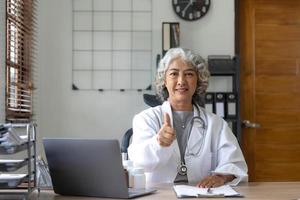 Portrait of Asian doctor working at her table in clinic