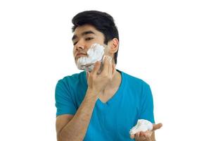 handsome young guy cares for a shaving foam and the person is isolated on a white background photo