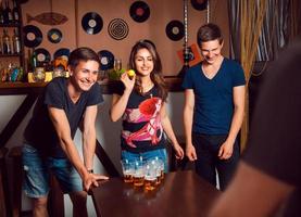 People having fun playing a beerpong at bar photo