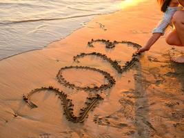 New year concept photo. Numbers 2023 handwritten in the sand surface. Soft sea wave and beach on background. photo