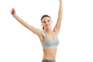 joyful young girl in grey top looks right and raises her hands up close-up photo