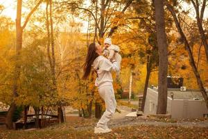 hermosa joven madre con bebé en otoño foto