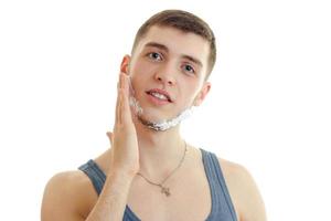 Portrait of a handsome young guy who looks straight into the camera and shaving foam on your face photo