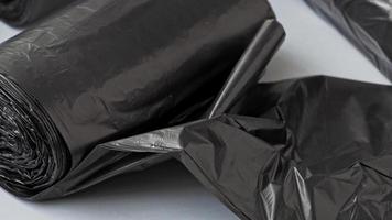 novos sacos de lixo pretos sobre um fundo branco. video