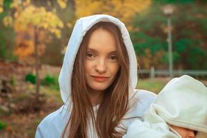 beautiful young mom with baby in autumn photo