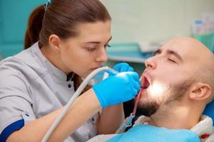 dentista curando a un paciente masculino foto