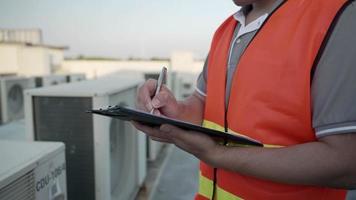 fabriek ingenieurs of personeel controle de koeling systeem van de fabriek. voor Mens records de staat van de compressor voordat onderhoud volgens onderhoud plan. video