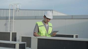 Utility Engineers are recheck the air condition on the roof deck of the factory. The designer of the Air condition system of the factory walked to check the system operation.Support engineer. video