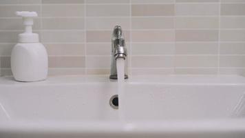 Man use hand closes the open water tap. Turning off the water when not in use saves energy helps environmental conditions and is cost-effective. Concept Preserve natural resources Save energy. video