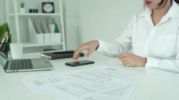 mulher de negócios usando um código de barras de digitalização de telefone celular e código qr. a empresária está verificando as informações dos documentos antes de efetuar os pagamentos por telefone. sistema on-line de conceito. video