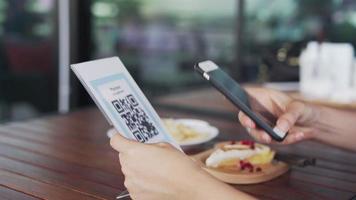 Woman use smartphone to scan QR code to pay in cafe restaurant with a digital payment without cash. Choose menu and order accumulate discount. E wallet, technology, pay online, credit card, bank app video