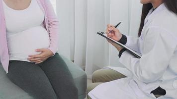 Pregnant women discussing a problem with a psychiatrist. The psychiatrist is note a detailed breakdown of the symptoms and putting them on the  record problem  for new pregnant woman. video