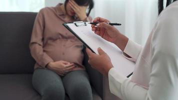 las mujeres embarazadas son tensión durante su embarazo de madre soltera. el médico registra el problema y alienta a la nueva mujer embarazada. concepto de madre soltera para bebé. psicóloga, consulta. video