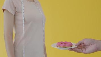 Diet concept. Women refuse to eat donuts and choose to eat apple.  Healthy women and strong bodies video