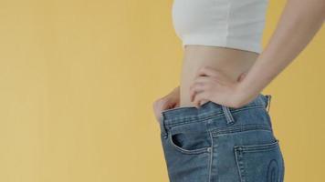 dieta donne mostrando risultati esercizio. donne avere un' ridotto dimensione dopo in corso un' peso perdita corse. donne non posso indossare jeans dovuto per peso perdita. concetto dieta per corpo forma. video