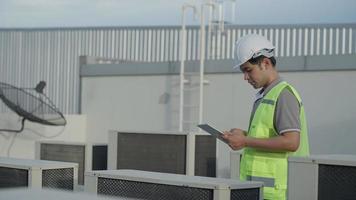 les ingénieurs des services publics revérifient l'état de l'air sur le toit-terrasse de l'usine. le concepteur du système de climatisation de l'usine a marché pour vérifier le fonctionnement du système. ingénieur de support. video