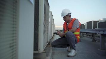 fabriek ingenieurs of personeel controle de koeling systeem van de fabriek. voor Mens records de staat van de compressor voordat onderhoud volgens onderhoud plan. video