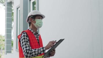 inspector o ingeniero está inspeccionando e inspeccionando un edificio o casa usando una lista de verificación. ingenieros y arquitectos o contratistas trabajan para construir la casa antes de entregársela al propietario. video