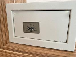 White iron small safe in the hotel room for storing valuables and money photo