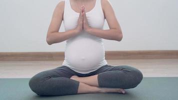 las mujeres embarazadas están haciendo ejercicios ligeros haciendo yoga para divertirse. Los ejercicios ayudan a mantener el cuerpo sano, aumentan la fuerza del feto y ayudan en el parto. concepto de punto de embarazo. video