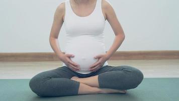 las mujeres embarazadas están haciendo ejercicios ligeros haciendo yoga para divertirse. Los ejercicios ayudan a mantener el cuerpo sano, aumentan la fuerza del feto y ayudan en el parto. concepto de punto de embarazo. video