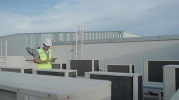 les ingénieurs des services publics revérifient l'état de l'air sur le toit-terrasse de l'usine. le concepteur du système de climatisation de l'usine a marché pour vérifier le fonctionnement du système. ingénieur de support. video