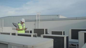 Utility Engineers are recheck the air condition on the roof deck of the factory. The designer of the Air condition system of the factory walked to check the system operation.Support engineer. video